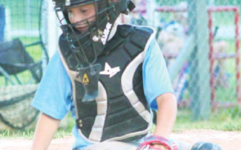 Wyatt Patton checks the dirt in the batter’s box to make sure it is all evened out for the next batter during the Mercy vs. Crossland 8U game recently.