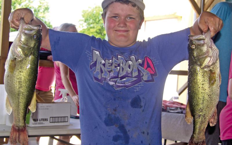 Had his catch been any bigger Kasden Fleshman would have needed help to lift his two big bass out of the creel. He was entered in the 49th Annual West Mineral Kids Fishing Tournament.