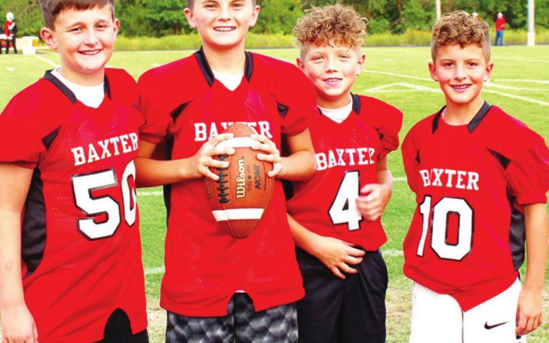 Up and coming football players help the Baxter Springs High School Lions by fetching water bottles, footballs and kicking tees during varsity games. Left to right: Weston Buck, Cole Parrish, Ethan McCoy, and Colt McCoy. Photo by Dee Riley.