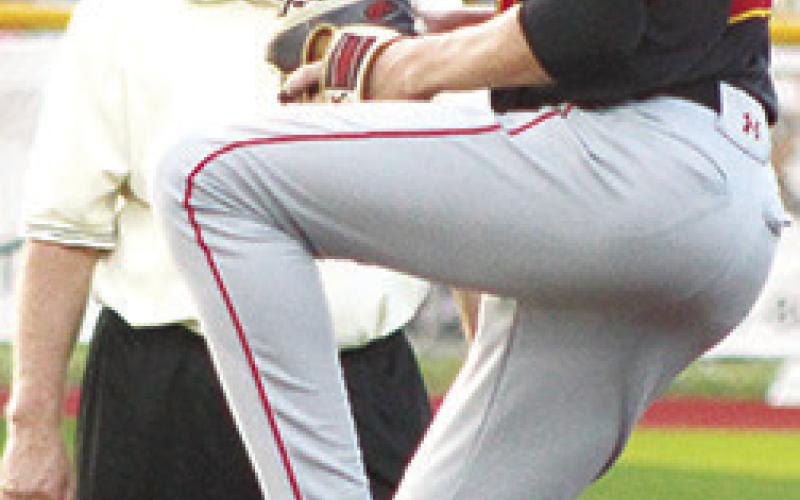 Umpire, Jay Wary, keeps a close eye on Titan Freshman Pitcher, Jonas Stover, as he tossed two strike outs and issued one walk with no hits and no runs to close out the final two innings of the win over the Trojans in Girard, Thursday.