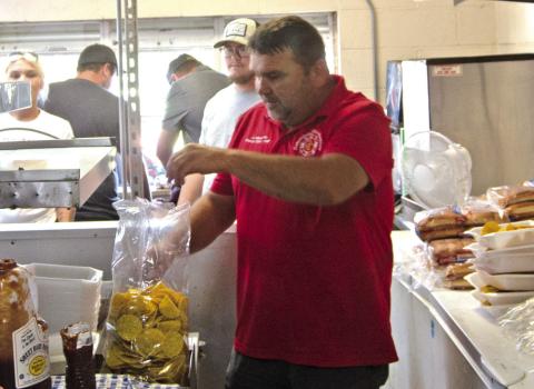 Former Columbus Fire Chief Jason Allison is helping his fellow fire firefighters at the Freedom Fest serving food a the Lions Shack. Allison is putting together the nacho cheese plates. The Festival was a great success according to reports from the fire fighters.