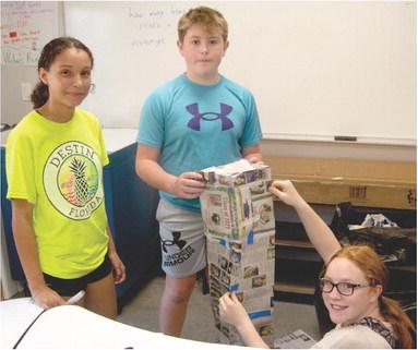 This may appear to be a class building project, but in fact the students in Nick Weber’s seventh grade class at Columbus Junior High School are learning about math, history and construction. They are building out of newspapers, replicas of the World Trade Center tower destroyed September 11, 2011. The students had to convert the building dimensions into centimeters and build a structure that would stand. Working on the project are Salece Marris, Jex Cheney and Mollie Sauerwein.