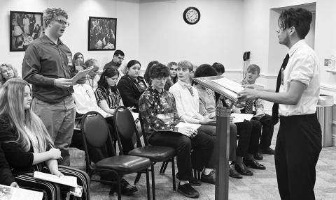 Layton Reynolds answers a question from AJ Gray (standing at left).