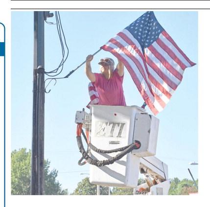 Though not a patriotic holiday, City of Columbus employee Kasie England worked Friday placing the U.S. flags on light poles down Maple Street and around the square for the Labor Day holiday.