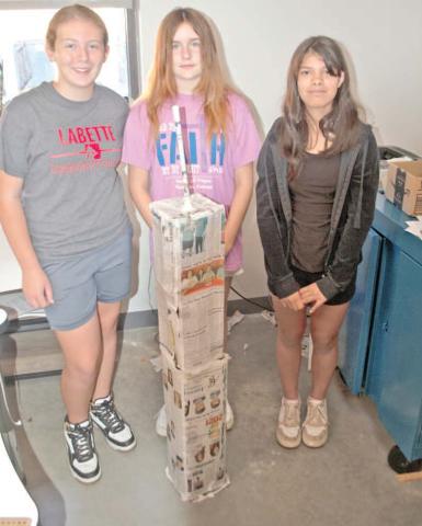 Standing behind their paper tower, Temperance Goff, Grace Alderman and Emily Soto, were first finished with the tower likeness including the antenna. This tower was judged among the best.