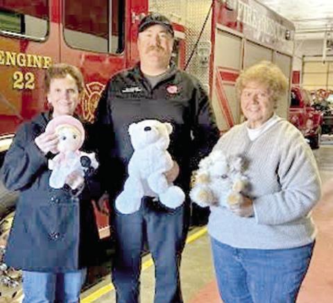 Representing Columbus Fire Department, Korey Lucian (center), accepted stuffed animals from members of the Cherokee County Retired School Personnel. The toys will be used to comfort children in emergency situations. Ann Thiele and Athena McColm, as well as Mary Torchia (not pictured) handed out the toys. Courtesy photo.