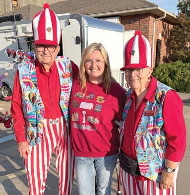 Bringing a colorful bunch of visitors to the Columbus Days celebration Monroe and Janet Neihart of Neihart Tours came to Columbus attired in balloon regatta dress. The Braddyville, Iowa tour spent the week-end in town. Monica Delmont, Chamber of Commerce Director, spent some time visiting with the couple. Courtesy photo.