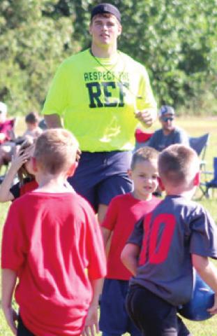 Referee, Kody Schalk, traded his Friday night football pads for a Saturday morning soccer ref shirt as the Columbus Area Youth Soccer League got underway, Saturday at Eddington Park. Courtesy Photo.