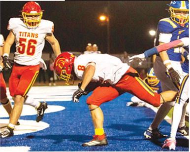 Braun Stone, Titan Senior, punches through the scrimmage line and across the goal line for a one-yard touchdown late in the Columbus win at Iola, Friday night. The Titans came home with a 33-21 win over the Mustangs with the help of Stone’s three rushing touchdowns. Teammate, Kash Smith, junior, met him in the end zone. Photo by Kristin Sharp.