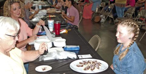 Violet Huddleson talks to the judges about her chocolate dipped cookies. Huddleson was participating in the foods judging held at the 4-H Building July 17. Photo by Destynne Goff.