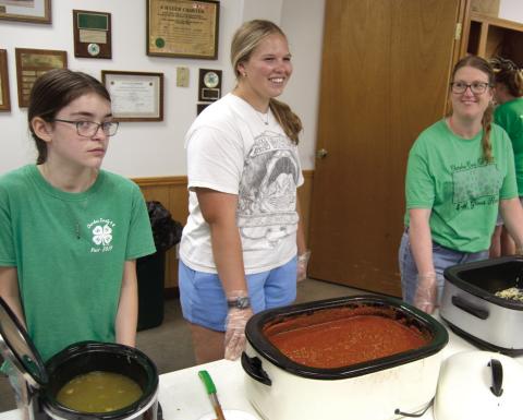 Plenty of help turned out for the fundraiser for the 4-H Building June 7. Kora Welch, Emma Walker and Laura Holmes were working in the serving line dishing up spaghetti with meat sauce and green beans. Funds raised will go to refurbishing the 4-H Building.