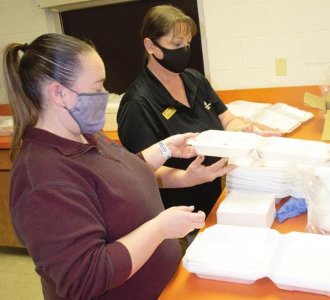 The first Fire Up for Fireworks cookout was held Thursday, Lindsey Morris and Sonja Duley were packing to go containers.