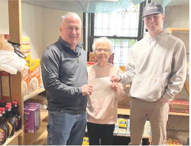 Gene Hamilton and Cameron Draeger with Optic Communications presented Sharon Draeger at the First United Methodist Church food pantry with a $1,000 donation. Courtesy photo.