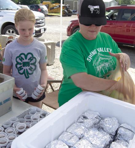 Riley Holmes and Josie Welch sack up burgers to “Feed the Farmers,” to fill the orders.