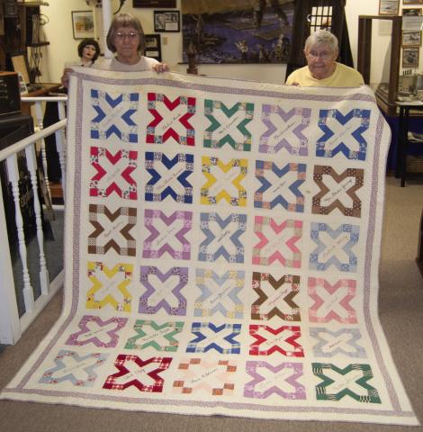 Holding the quilt donated to the museum by Annette Lopp Robertson are Doris Richardson and Carol Phelps.