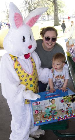 Eighteen month old Luca Knight, of Olathe, held by his mother Paige as the Easter Bunny presents him with a roll-around trike following the Columbus Chamber of Commerce Easter Egg Hunt on Saturday. He won in the under two years old division.