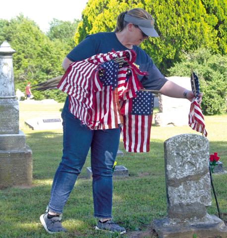 Friday afternoon the Welch family spent the afternoon putting American Flags on veterans graves at both the Park and Columbus cemeteries. Crystal is shown planting flags in the Columbus Cemetery.