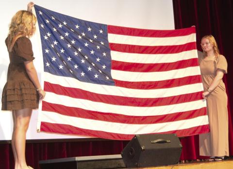 Flag bearers Kenadie Carter and Chloe Rogers ended the Veterans Day program by folding the flag as Mallory Thompson and Lydon Lovesee played “Taps.”