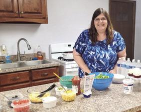 County 4-H Extension Agent Valori Stone stands behind the table at her going away party on Thursday. Stone will be taking a new position with the Wildcat District Extension Office in Fredonia.