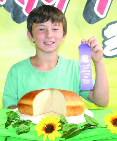 Hunter Davis shows his purple ribbon and his loaf of bread he entered into the Cherokee County foods show.
