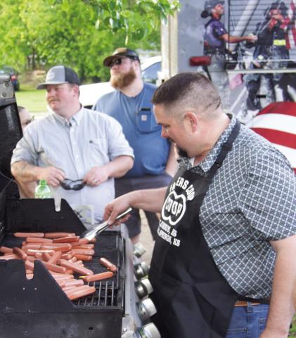 Preparing for the hot dog eating contest Matt Case, manager of the Cherokee County Farmers Coop, was at the grill. Hundreds of the tasty treats were prepared for the contest and the free hot dogs were provided by Moates Excavating for the Cowtown Days in Baxter Springs.