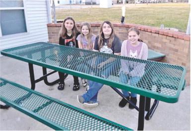 Area Girl Scouts Alyssa Montierth, Lilly Linam, Raygen Spoonemore and Eleanor Holt sit at the new tables installed at the Girl Scout House in Columbus. The tables were made possible by a grant from the SEK Community Foundation. Courtesy photo.