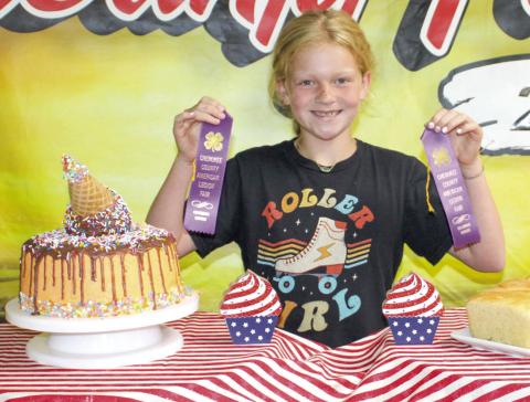 Showing her purple ribbons, Adley Hess made a creatively decorated cake. It looks as if an ice cream cone is melting down the sides, creating the icing.