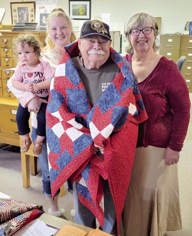 The presentation of a Quilt of Valor to Columbus native Homer Wayne Dobkins at the Columbus Genealogical Society meeting last week. Dobkins, a Navy veteran is the vice-president of the genealogical society. Attending the presentation was Wayne’s wife Juanita his granddaughter Aspen Miller and greatgranddaughter Atlas Peters.