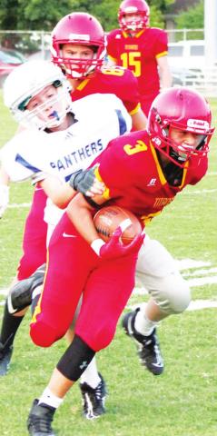 Jayden Rodriguez, Titan Eighth Grader, narrowly escapes the grasp of Panther defender, Charlie Gill, in Thursday’s loss to St. Mary’s-Colgan, 38-8 at Titan Stadium. Kooper Saiz and Jett Tanner can also be seen.