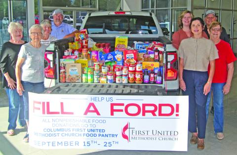 The Ford pick-up truck loaded with 840 pounds of groceries, collected by Mike Carpino Ford was delivered to the Columbus United Methodist Church food pantry after two weeks of collection. Those with the truck include on the left side Nancy Evans, Sharon Draeger, Sue McKenzie and Robbie Carpino. On the right-side, Jamie Huston, Jay Wary, Hannah Carpino and Anita Davolt.