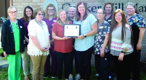 Quaker Hill Manor recently received an award for transitioning to gold status. Those accepting the award included front row Debbie Hopkins, Amy Bailey, Mandy Kinsley, Karen Stockton, Rhonda McDonald. Back row Susie Reed, Goldie Hubbs, Marissa Shaurette, Jan Edwards, Liz Schoenfeld, Rhonda Carter.