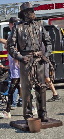 One of the entertainers at the Columbus Day Festival was a human statue. He was dressed as a bronze cowboy sculpture. Photo by Neva Hiatt.