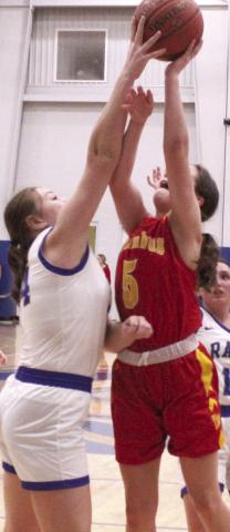 EJ Wells, Riverton Junior, appears to have “all ball” but her arm and body tell a different story on a shot attempt by Lady Titan Freshman, Ellie Helms, in the 28-25, Lady Ram win over Columbus, Friday, in Riverton.