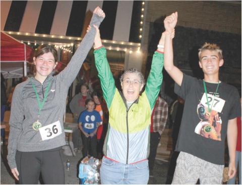 Band director Gae Phillips congratulates two of the winners of the Zombie run sponsored by the Columbus High School Band. The Zombie Run is looked forward to by many runners in the area.