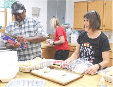 Bill Jones and Susan Shultz were among the volunteers preparing the meal for the Community Christmas dinner Saturday.