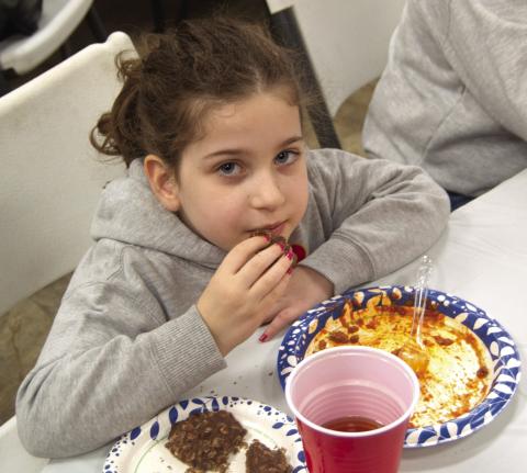 Nothing like finishing a meal with homemade cookies, says Finley Sanders after enjoying spaghetti during the Jon Tavenaro benefit at the Community Center in Weir on Saturday. The successful benefit included a large silent auction.