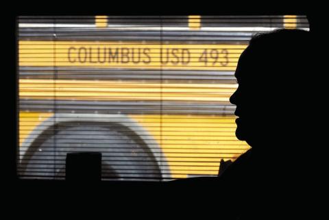 The silhouette of third grade teacher Bekah Noel, at the end of a school day watches her students load onto busses. AP Photo Nick Ingram.
