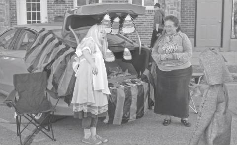 Many of the booths at the annual Halloween trunk or treat event decorated with creative costumes and banners. Alice and candy corn were part of this booth.