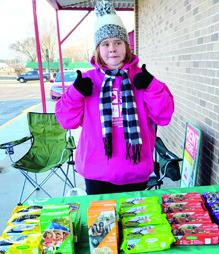 Local Girl Scout Izzy Manus has two thumbs up for cookie sales. Look for booths set up around Cherokee County to get your cookies. Courtesy photo.
