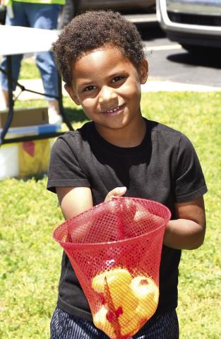 Park elementary kindergarteners celebrated the end of the school year with some last minute carnival fun. Teachers set up and launched a mini carnival at the school including multiple activities. They had a tattoo station, catch the ducks station, boardwalk game, outdoor tic tac toe, ribbon wand fun and popcorn and cotton candy. Youngsters were also given the chance to pose in the carnival photo booth. Ezequiel Lee had just tried his hand at the duck booth. Photo by Tanya Woolsey.