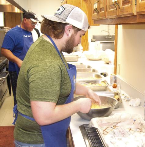Chip Herrenbruck (back) and Peyton Herrebruck were on cooking duty. Peyton was coating the filets with batter before they went into the fryer.