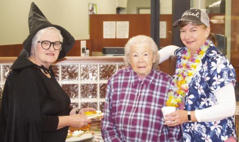 The staff and customers were enjoying the refreshing apple cider and cookies Friday during the annual Commerce Bank Customer Appreciation Day. Patty Dunnic was dressed as a witch, bank customer Eva Forkner was receiving refreshments from Janette Crain dressed for a Hawaiian trip. News-Report photo by Shawn Churchill.