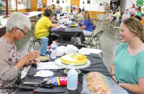 Emma Walker, 4-H member, speaks with one of the judges during the foods show. Walker explained her projects to the judge, discussing ingredients, methods and other facets of her entry.