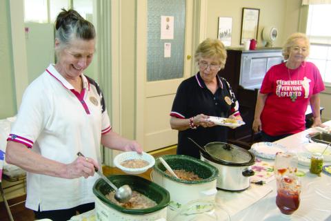 Sharon Day, Baxter Springs American Legion Auxiliary President, dips up beans at the recent bean feed. Assisting with the serving line were Sherry Shackleford and Justine Keenan.