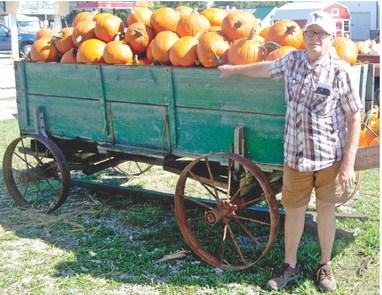 Columbus businessman Delbert Rowden stands next to a wagon load of pumpkins he brought into town for his final Pumpkin Patch. Delbert and Sheryl Rowden will no longer continue the Halloween.