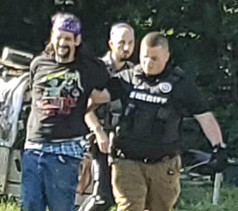 Sean Galloway surrendered to Cherokee County law enforcement after a short standoff Wednesday. He was escorted to the patrol car by Nate Jones. Courtesy photo.