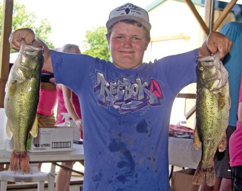 Had his catch been any bigger Kasden Fleshman would have needed help to lift his two big bass out of the creel. He was entered in the 49th Annual West Mineral Kids Fishing Tournament.