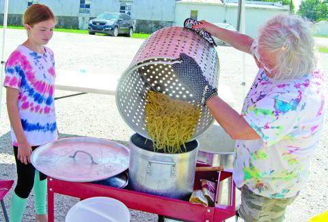 4-H’er Kate Martin watches as Rhonda Herrenbruck pours the spaghetti from the large cooking pot into the serving pan. Several different places were used to cook the spaghetti as the amount was overwhelming. The 4-H clubs are hoping to remodel the 4-H club building built in 1991.