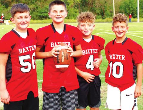 Up and coming football players help the Baxter Springs High School Lions by fetching water bottles, footballs and kicking tees during varsity games. Left to right: Weston Buck, Cole Parrish, Ethan McCoy, and Colt McCoy. Photo by Dee Riley.