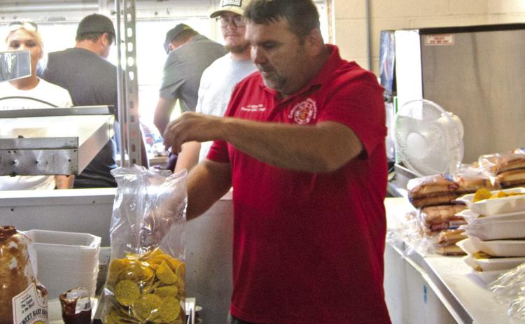 Former Columbus Fire Chief Jason Allison is helping his fellow fire firefighters at the Freedom Fest serving food a the Lions Shack. Allison is putting together the nacho cheese plates. The Festival was a great success according to reports from the fire fighters.